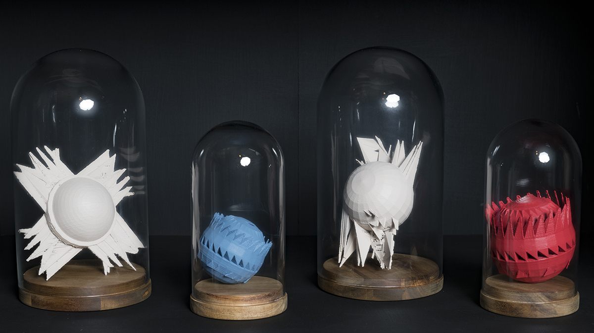 Four exoplanet models in white, blue, and red housed in bell jars.